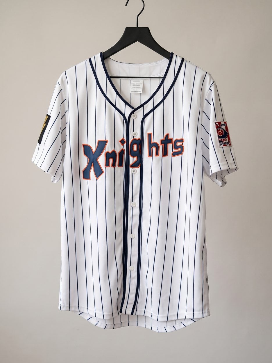 This jersey on a hanger, close enough to see the stitching, the fabric and the tags