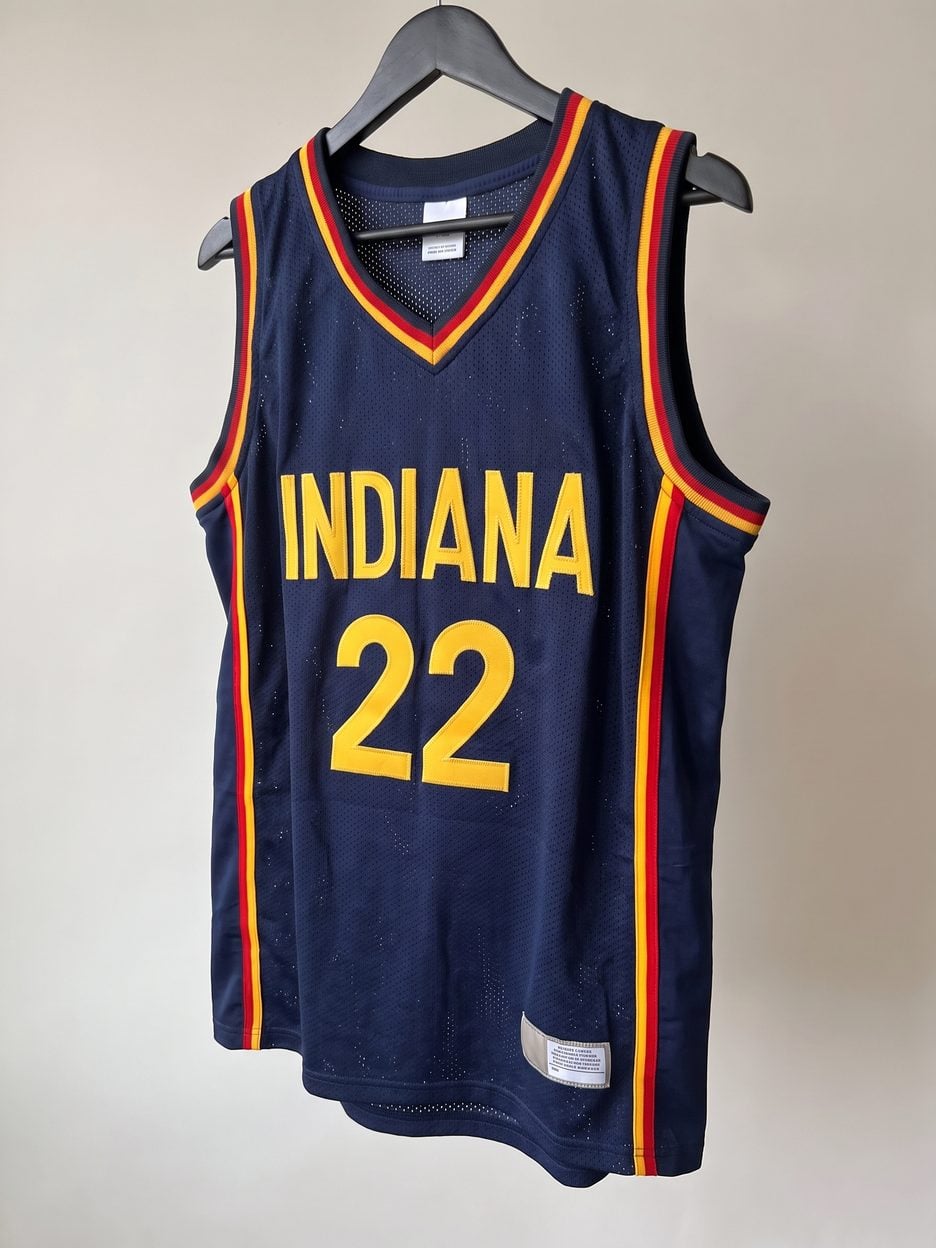 This jersey on a hanger, close enough to see the stitching, the fabric and the tags