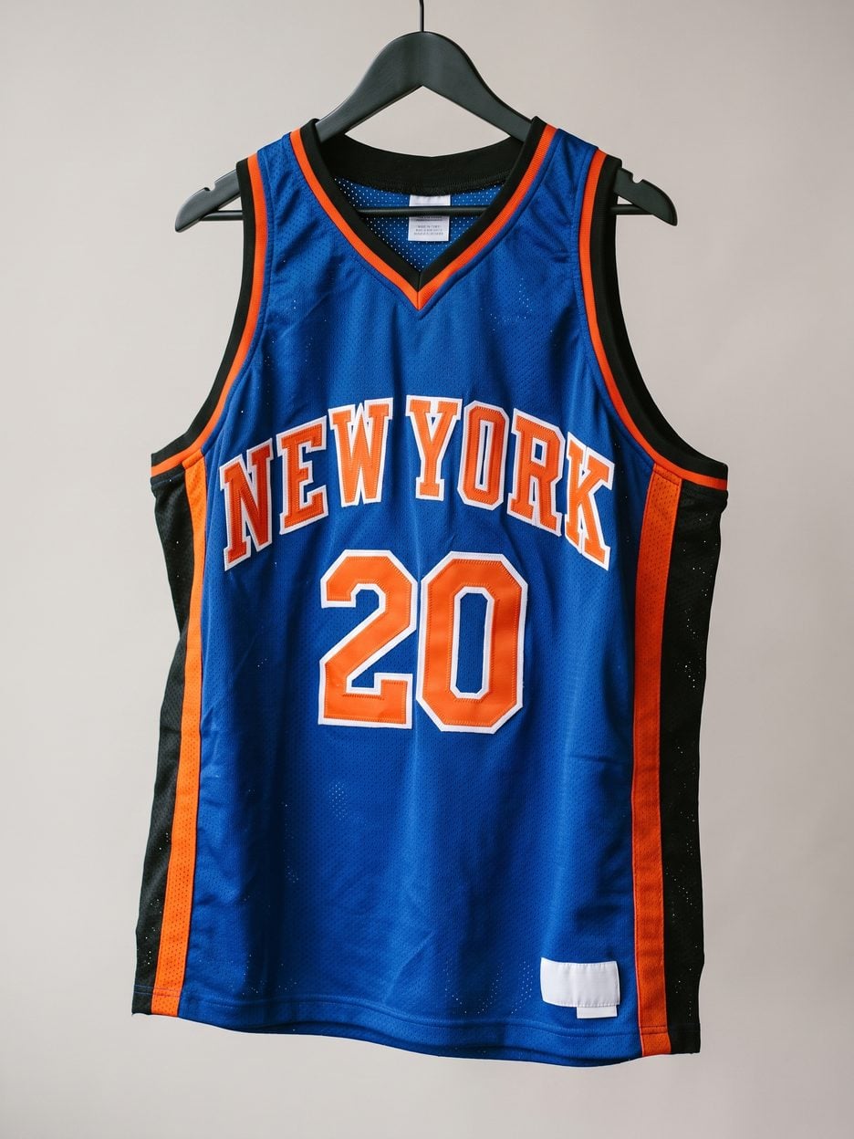 This jersey on a hanger, close enough to see the stitching, the fabric and the tags