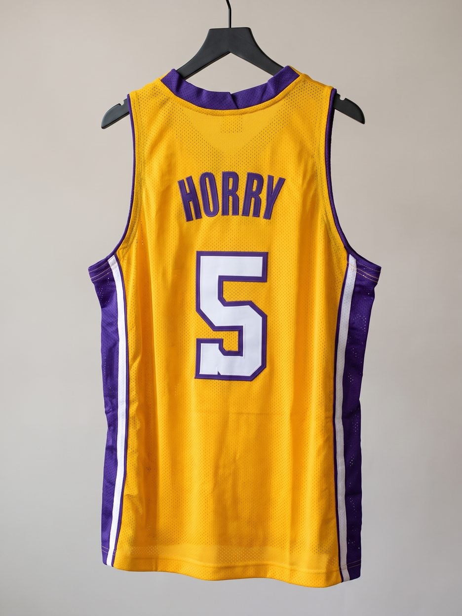 This jersey on a hanger, close enough to see the stitching, the fabric and the tags