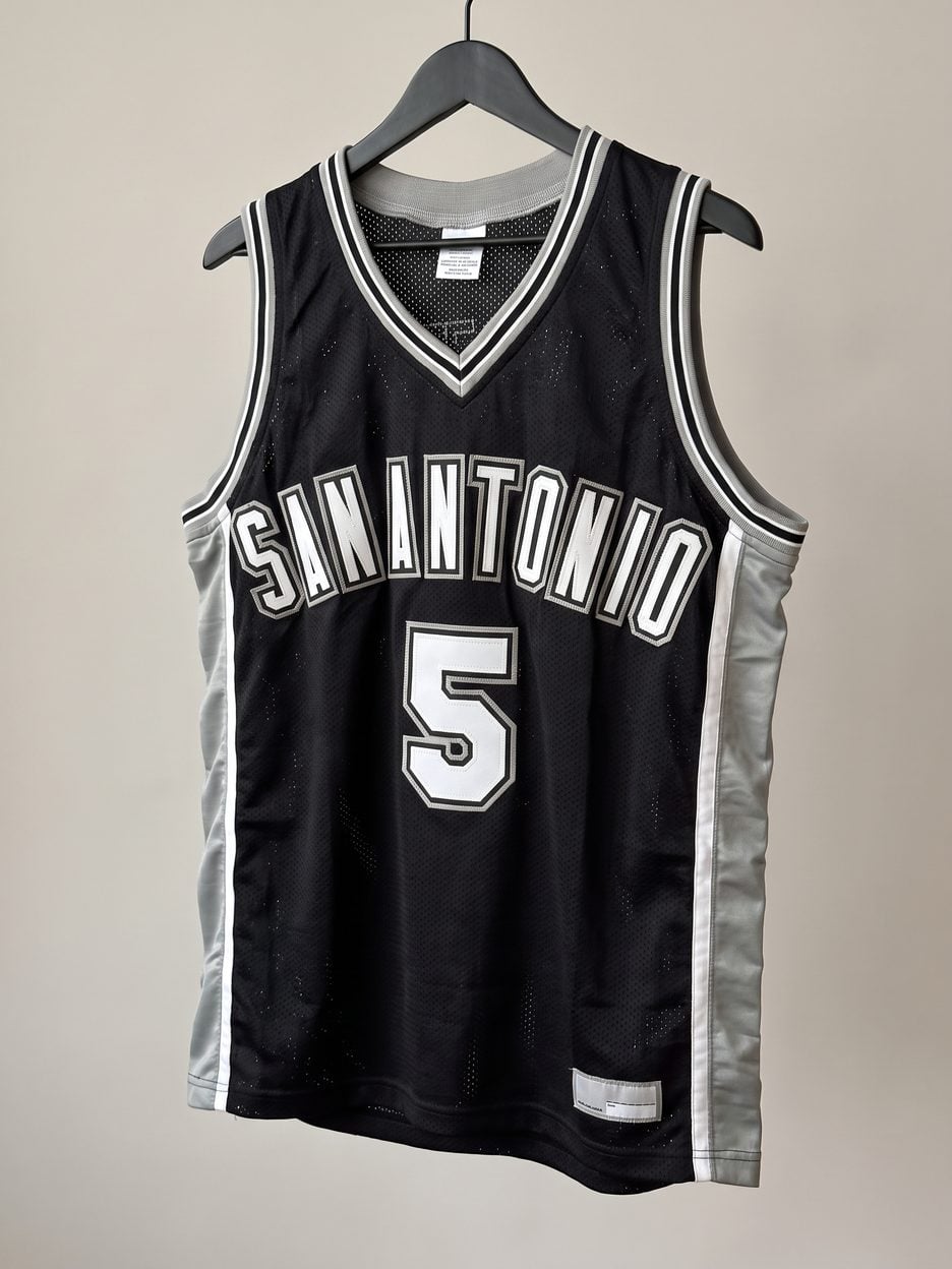 This jersey on a hanger, close enough to see the stitching, the fabric and the tags