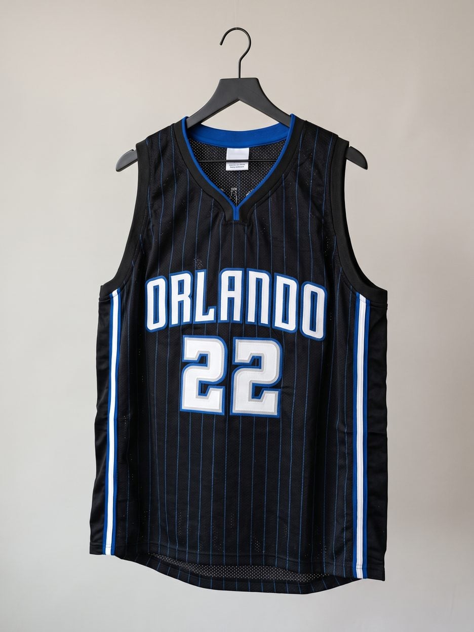 This jersey on a hanger, close enough to see the stitching, the fabric and the tags