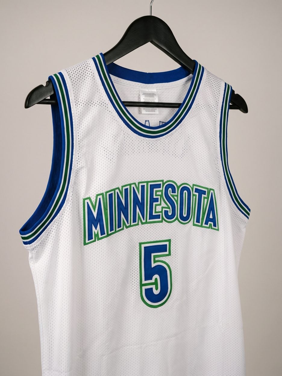 This jersey on a hanger, close enough to see the stitching, the fabric and the tags