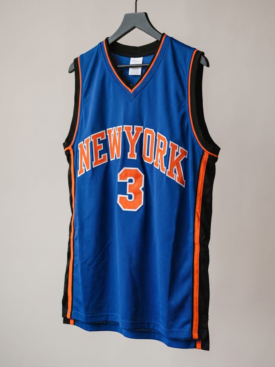 This jersey on a hanger, close enough to see the stitching, the fabric and the tags