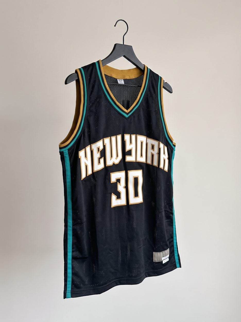 This jersey on a hanger, close enough to see the stitching, the fabric and the tags