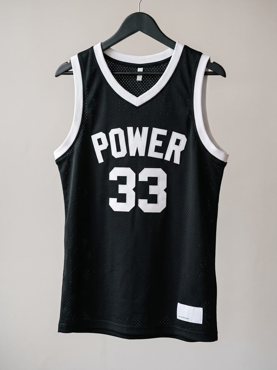 This jersey on a hanger, close enough to see the stitching, the fabric and the tags